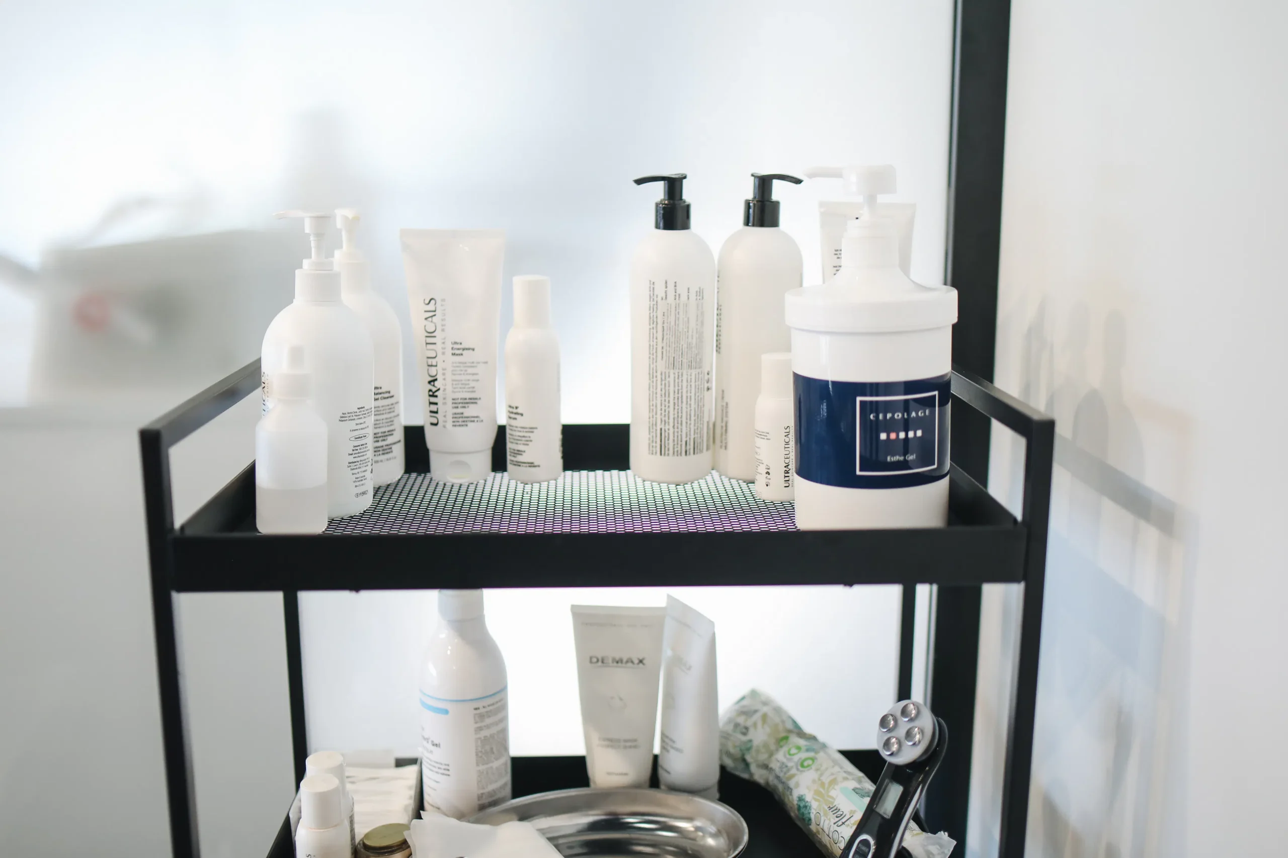 A collection of waxing aftercare products, such as soothing lotions and gentle exfoliants, displayed on a shelf in a waxing salon.