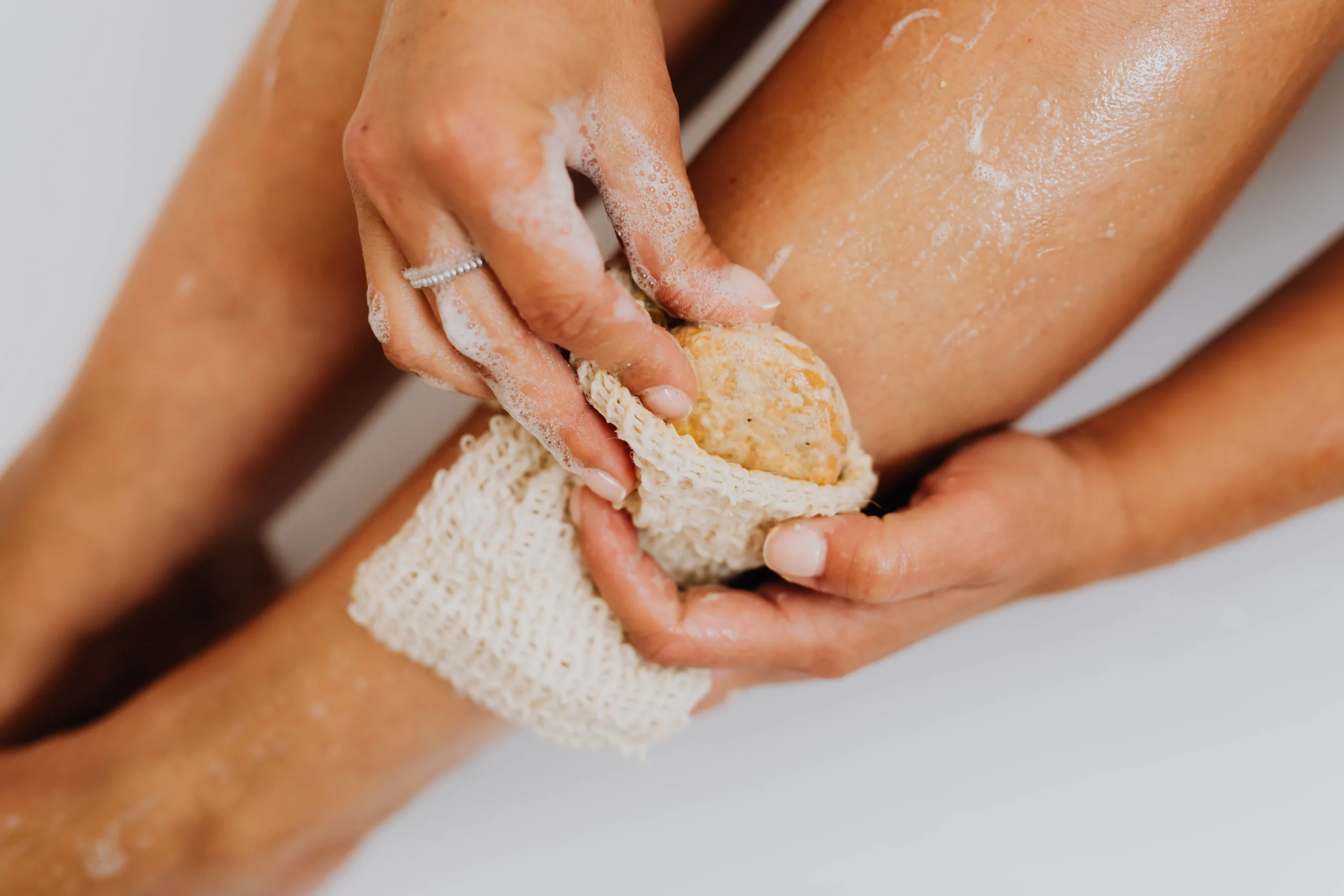 A close-up shot of a person gently exfoliating their skin with a soft brush, preventing ingrown hairs.