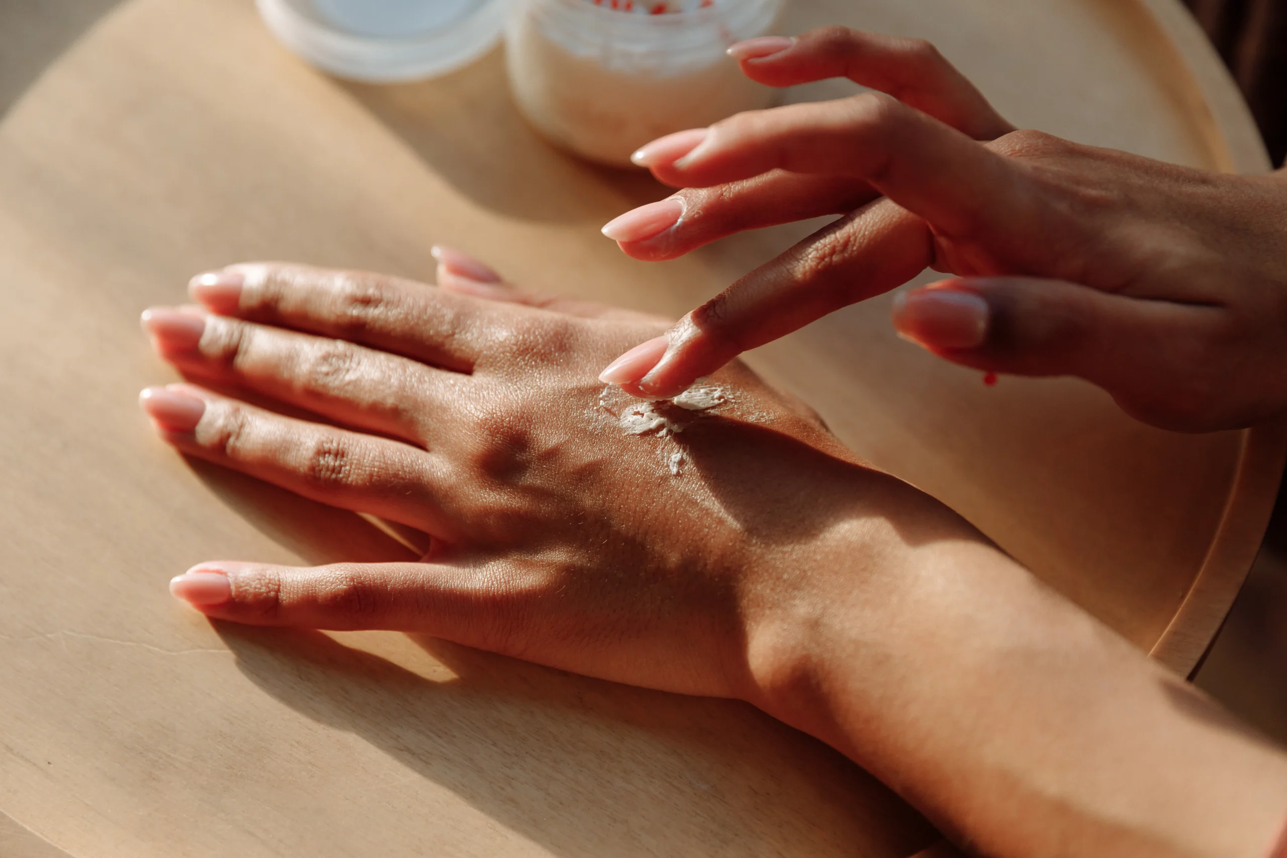 A woman applying numbing cream to her legs before waxing. Alt text: Use numbing cream for a more pain-free waxing experience and achieve smooth skin.