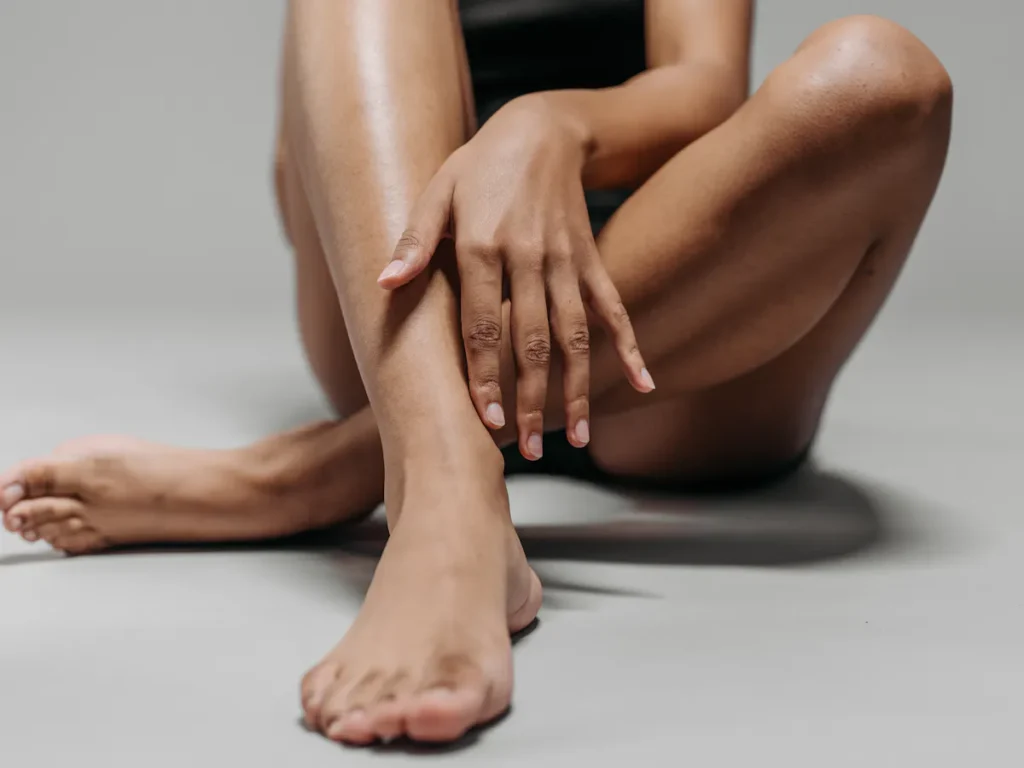 A woman with smooth, glowing legs after laser waxing