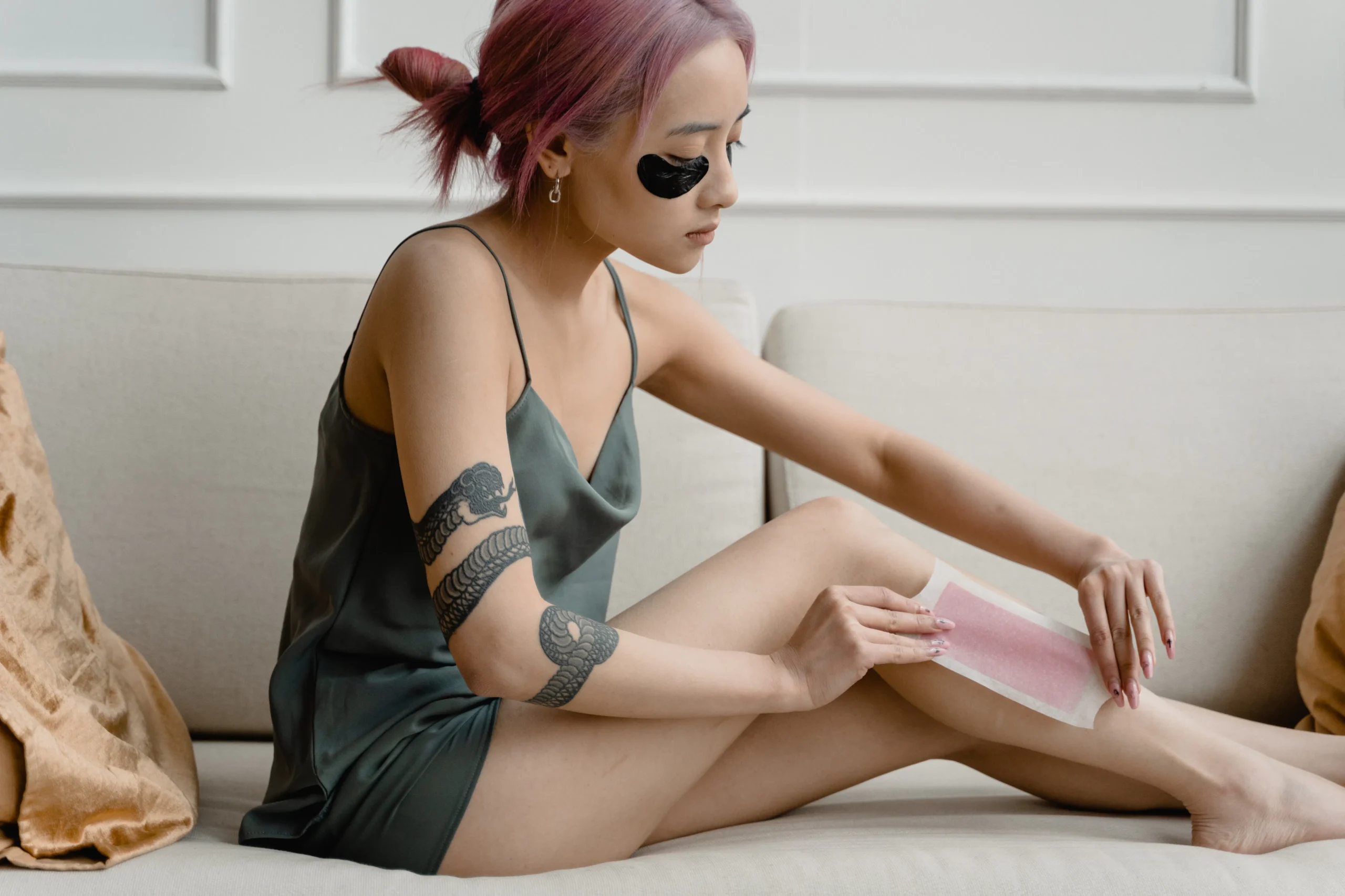 Close-up of waxing strips being applied to a leg, demonstrating the process of hair removal. alt_text: Applying waxing strips for leg hair removal