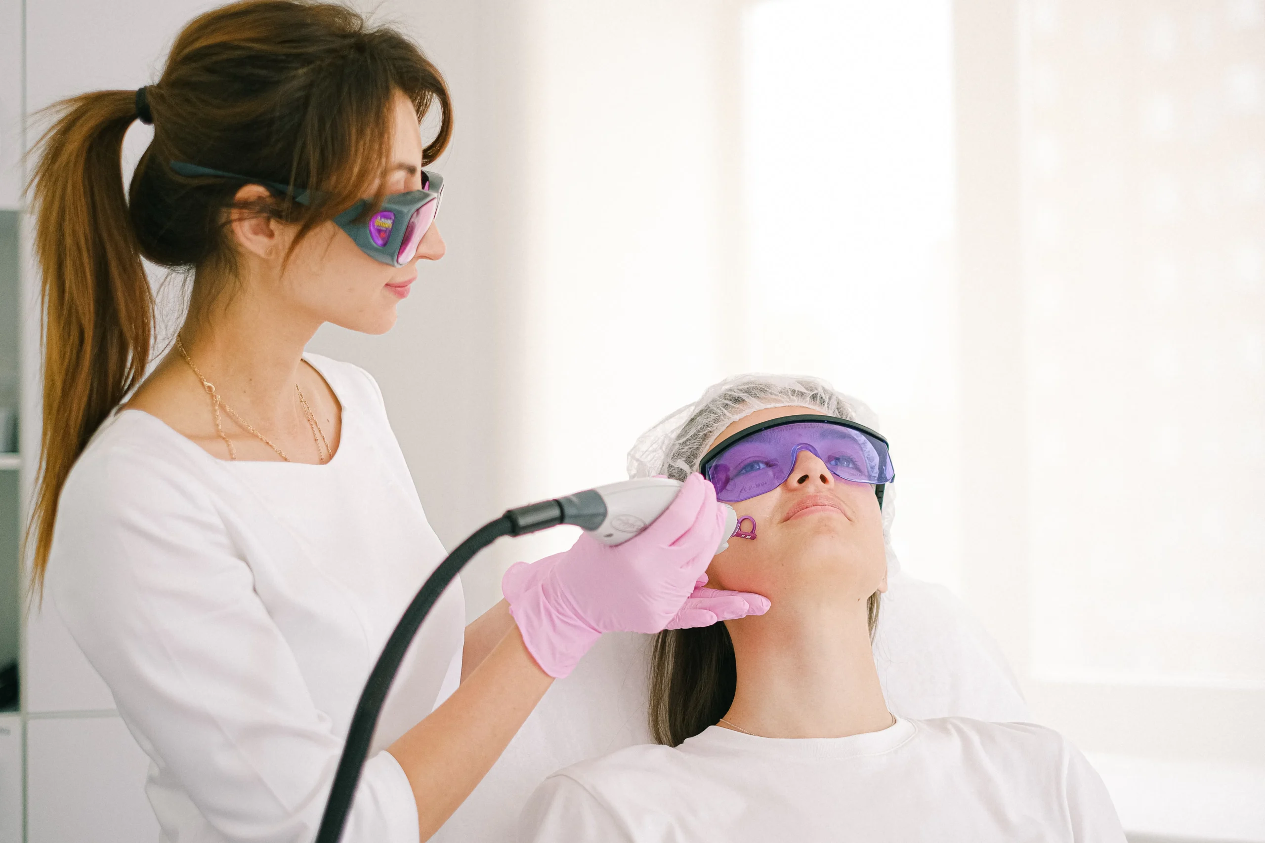 A professional performing laser hair removal on a patient's face, a procedure for permanent hair reduction.