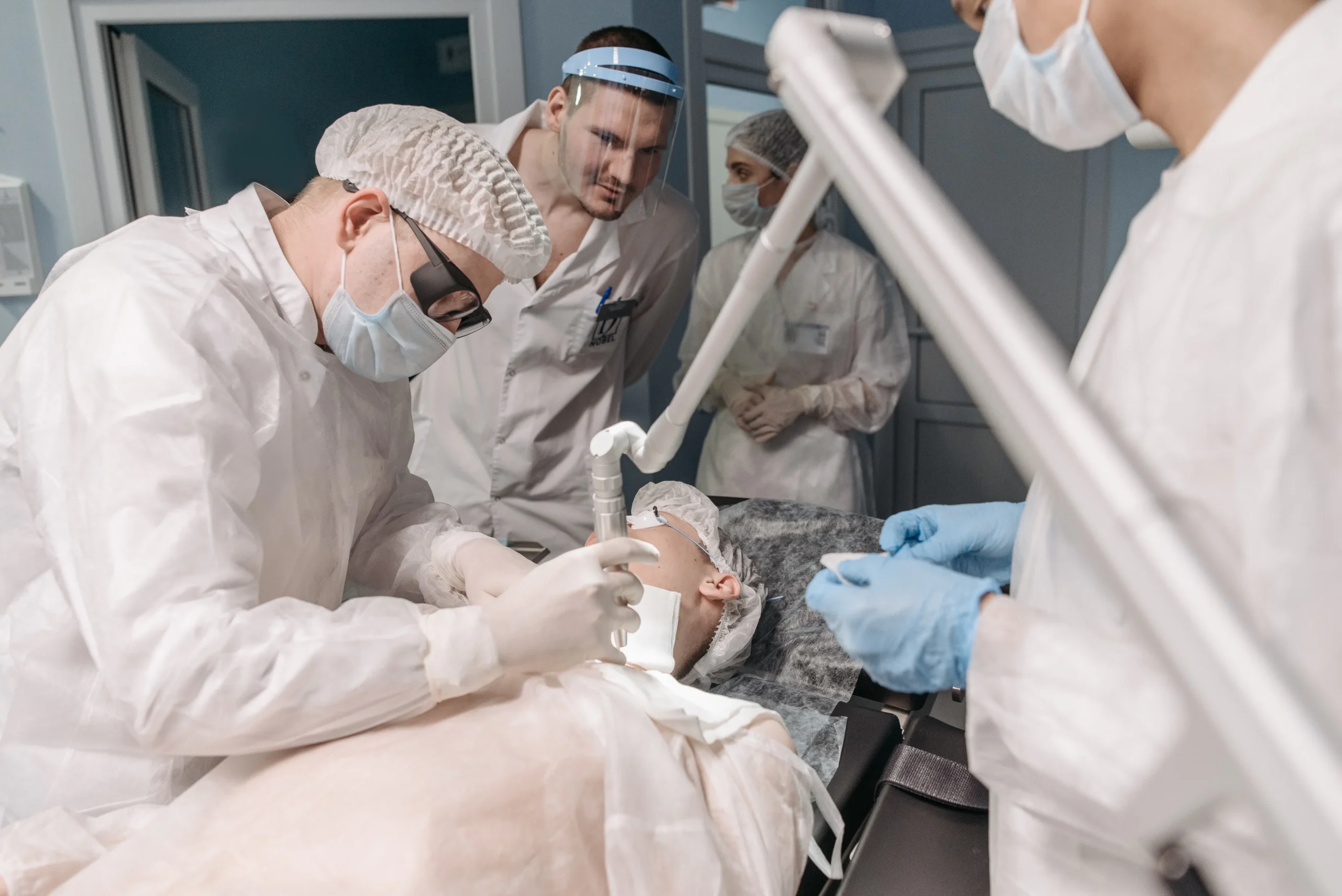 A medical team performs a procedure on a patient, possibly related to laser treatment or cosmetic surgery.
