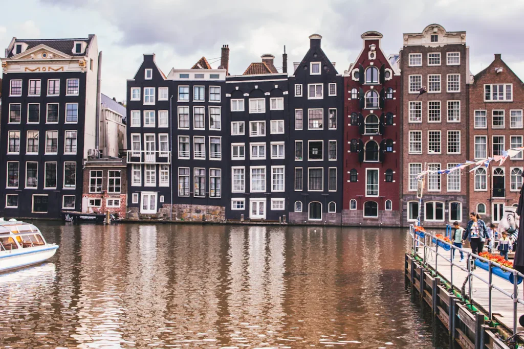 Amsterdam canal view with historic buildings and boat on the water.