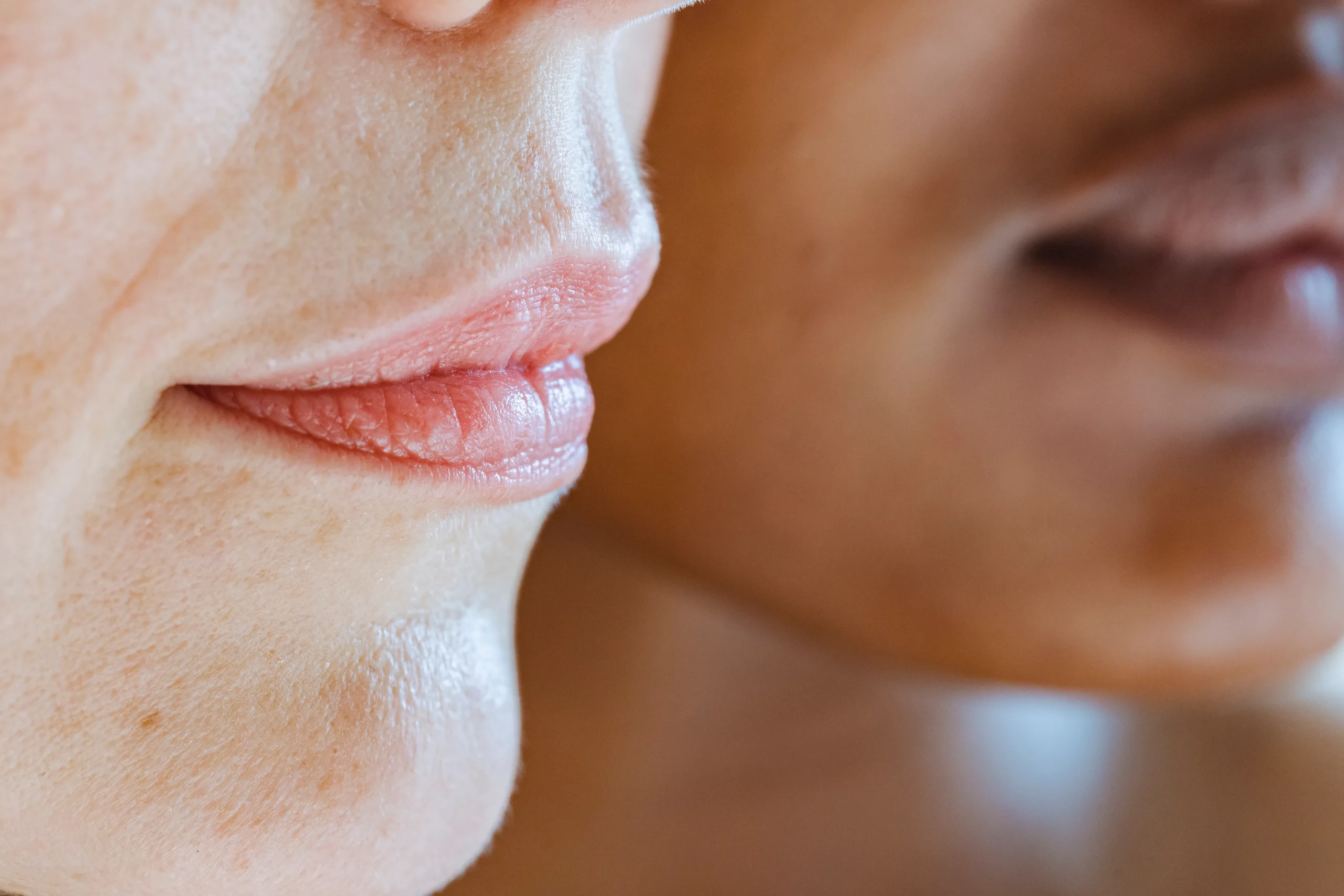 Close-up of a woman's lips and chin with visible skin texture and detail.