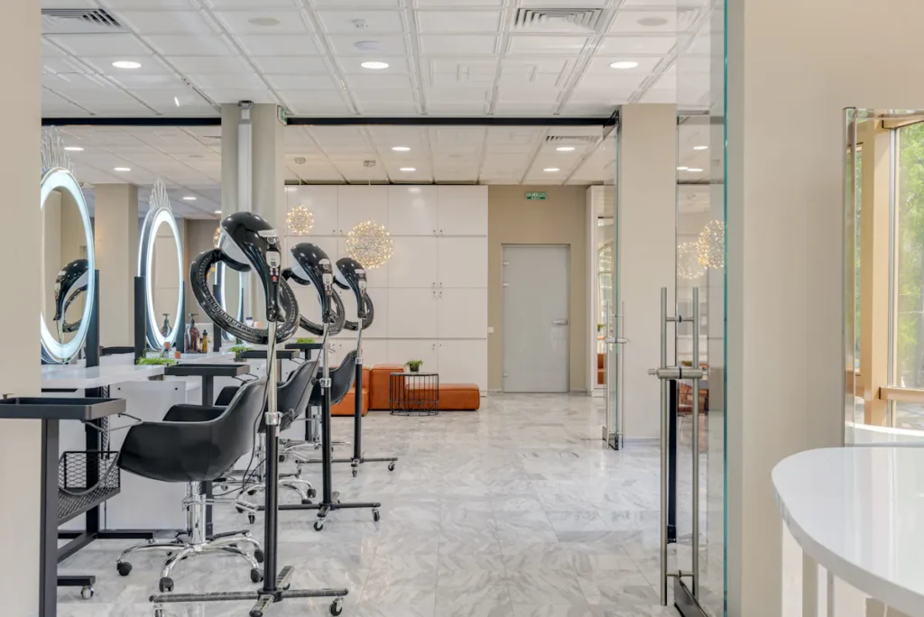 Bright, modern Amsterdam waxing salon interior with chairs, mirrors, and hair dryers.