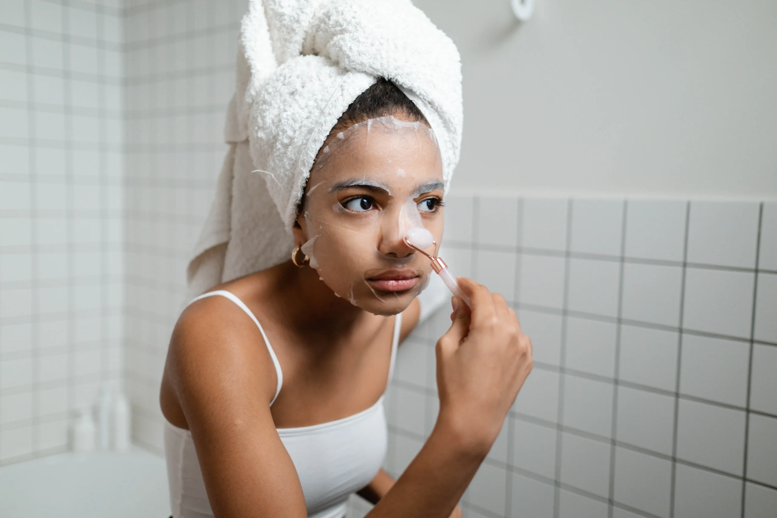 Woman applying a facial sheet mask, prepping for smooth skin waxing.