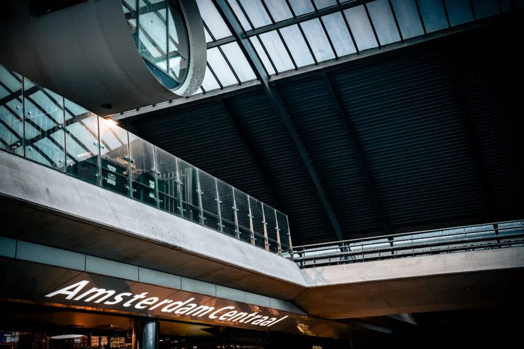Amsterdam Centraal station interior with modern architecture and glass ceiling.