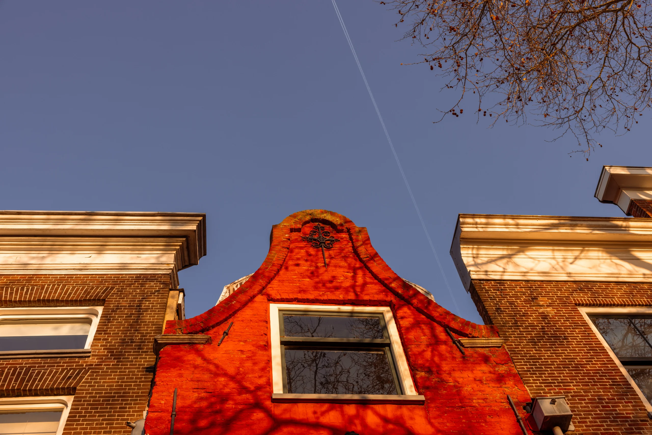Amsterdam architecture: Red brick building with stepped gable against a blue sky.