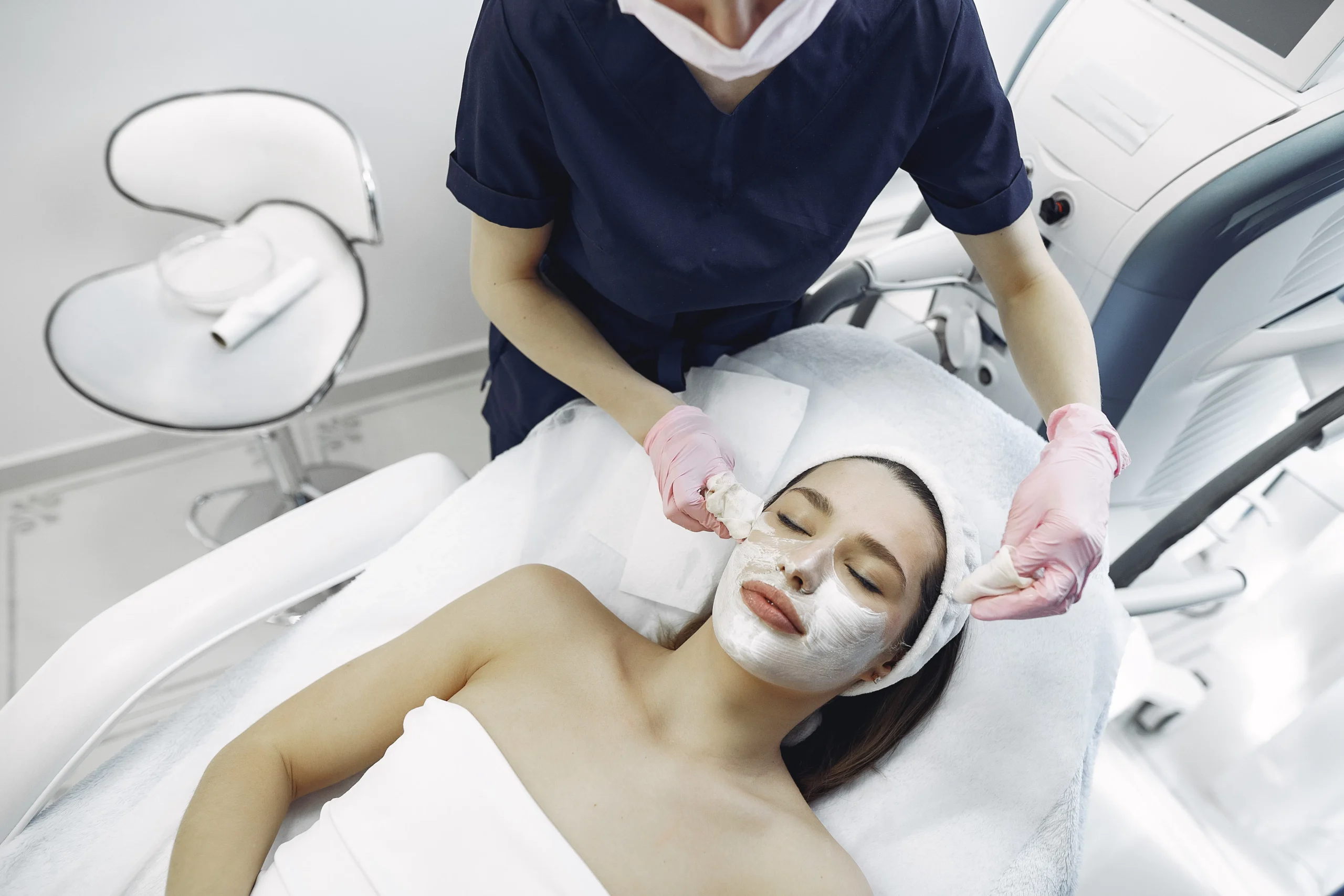 Woman receiving a facial treatment with white mask at a skin clinic in Amsterdam
