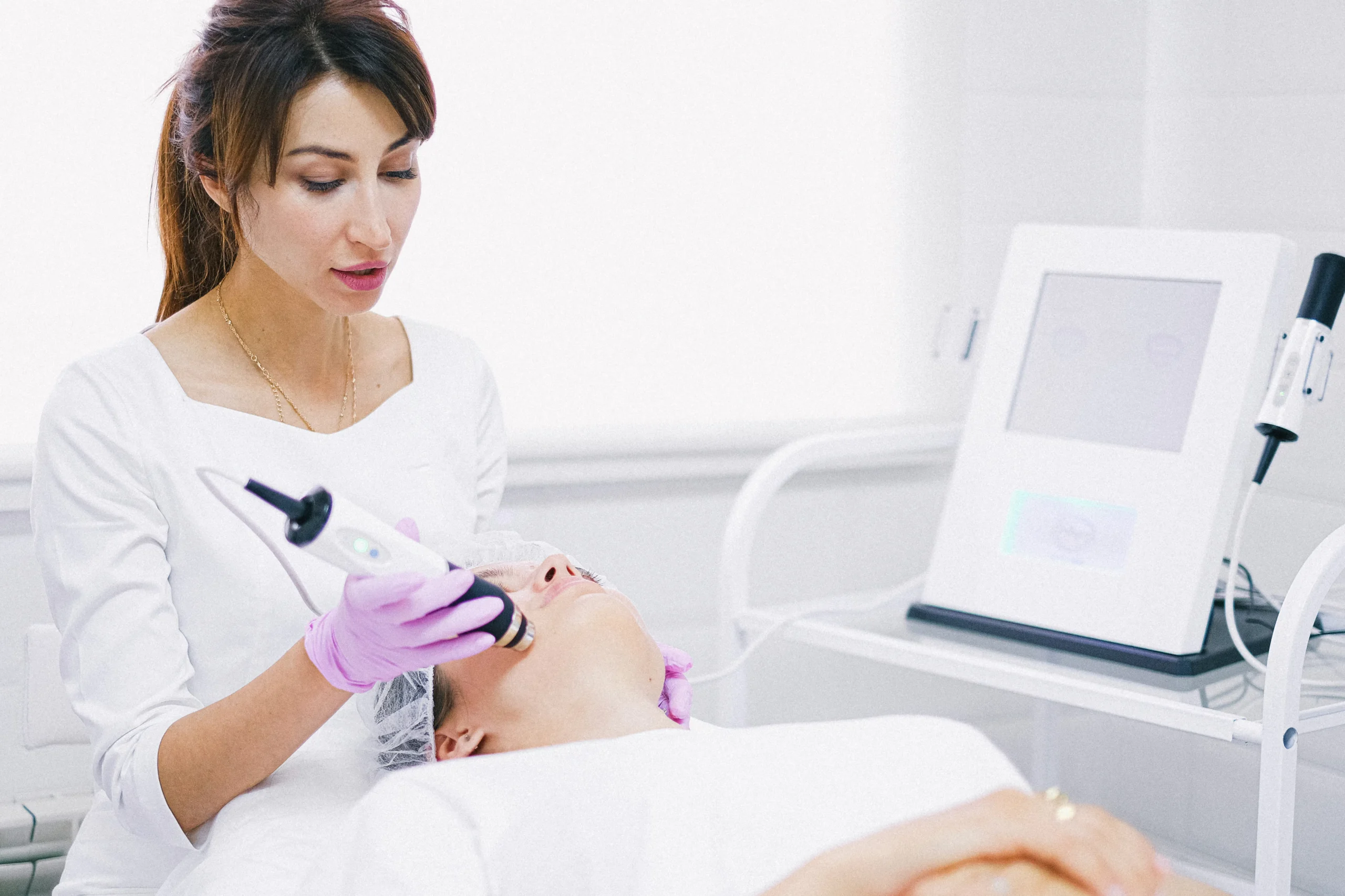 Aesthetician performing carbon laser facial in Amsterdam, skin rejuvenation treatment.