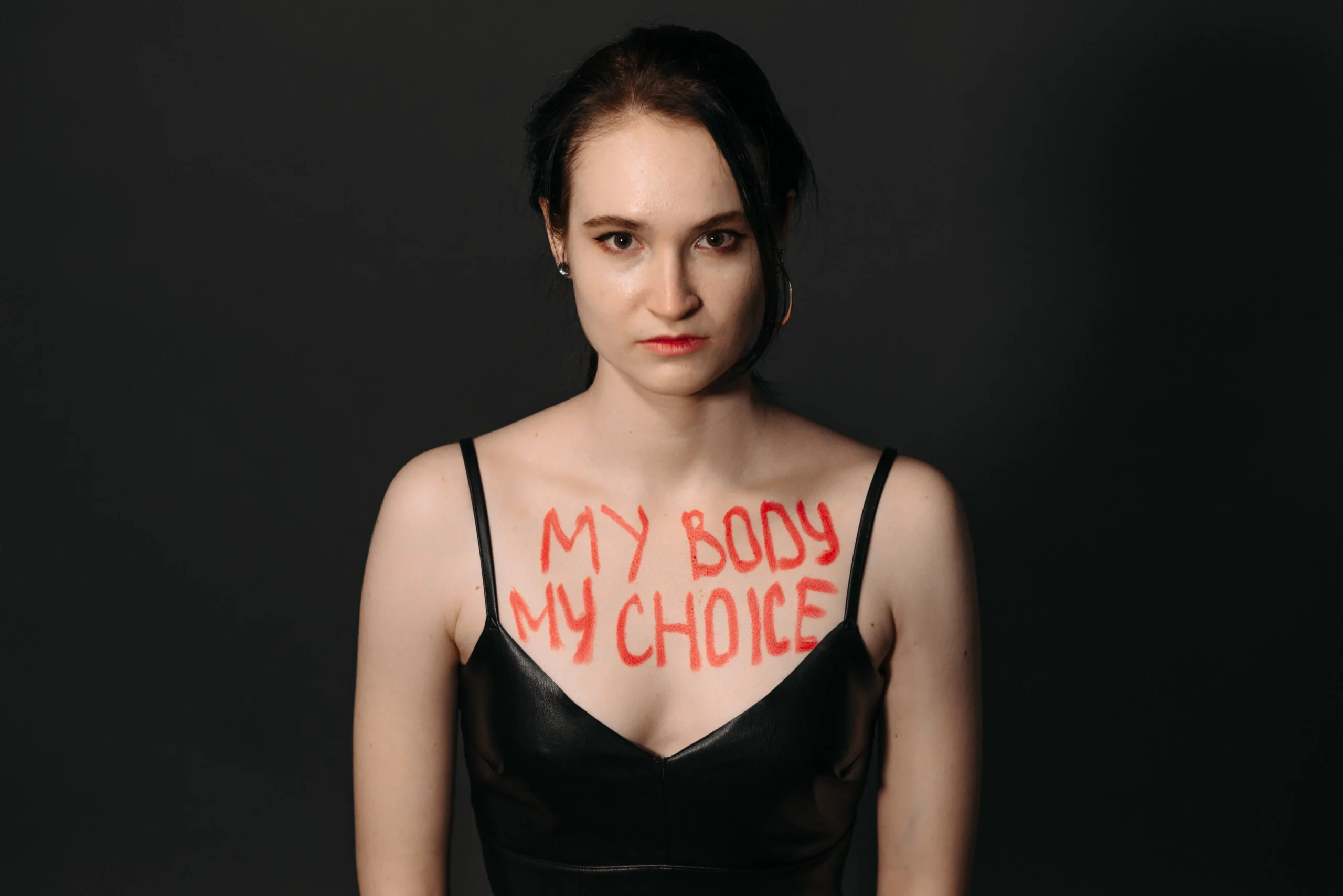 Woman with MY BODY MY CHOICE written on her chest in red paint.