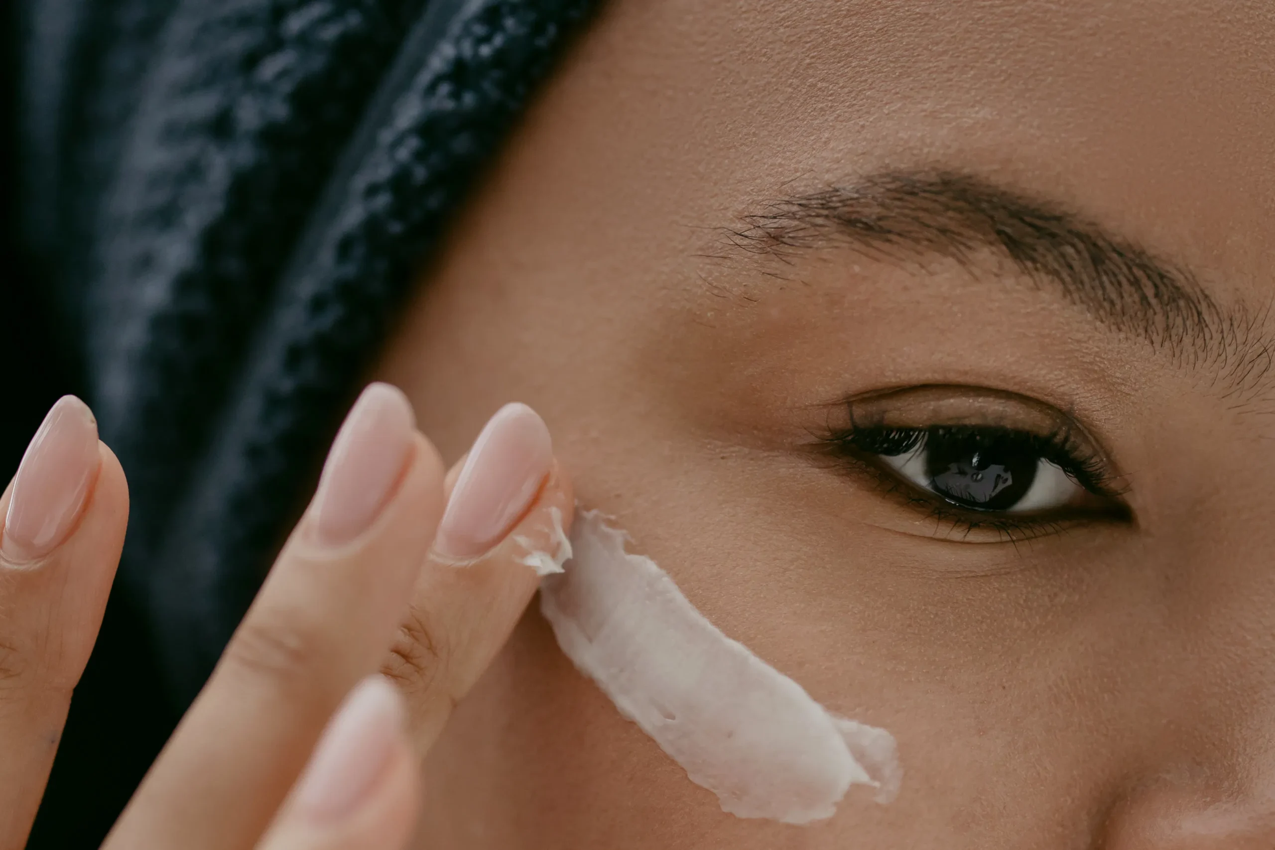 Close-up of woman applying cream to face for skin rejuvenation in Amsterdam