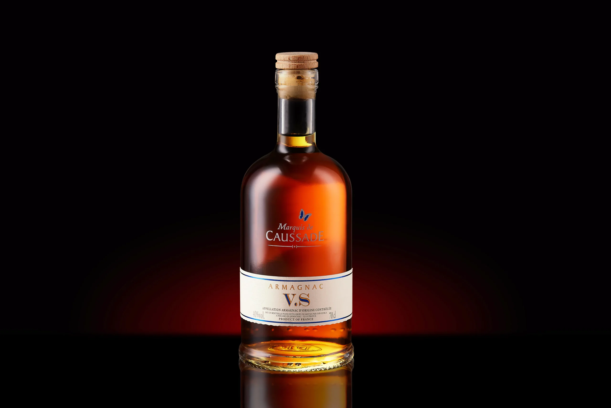 Bottle of Armagnac V.S. against a dark background with red light.