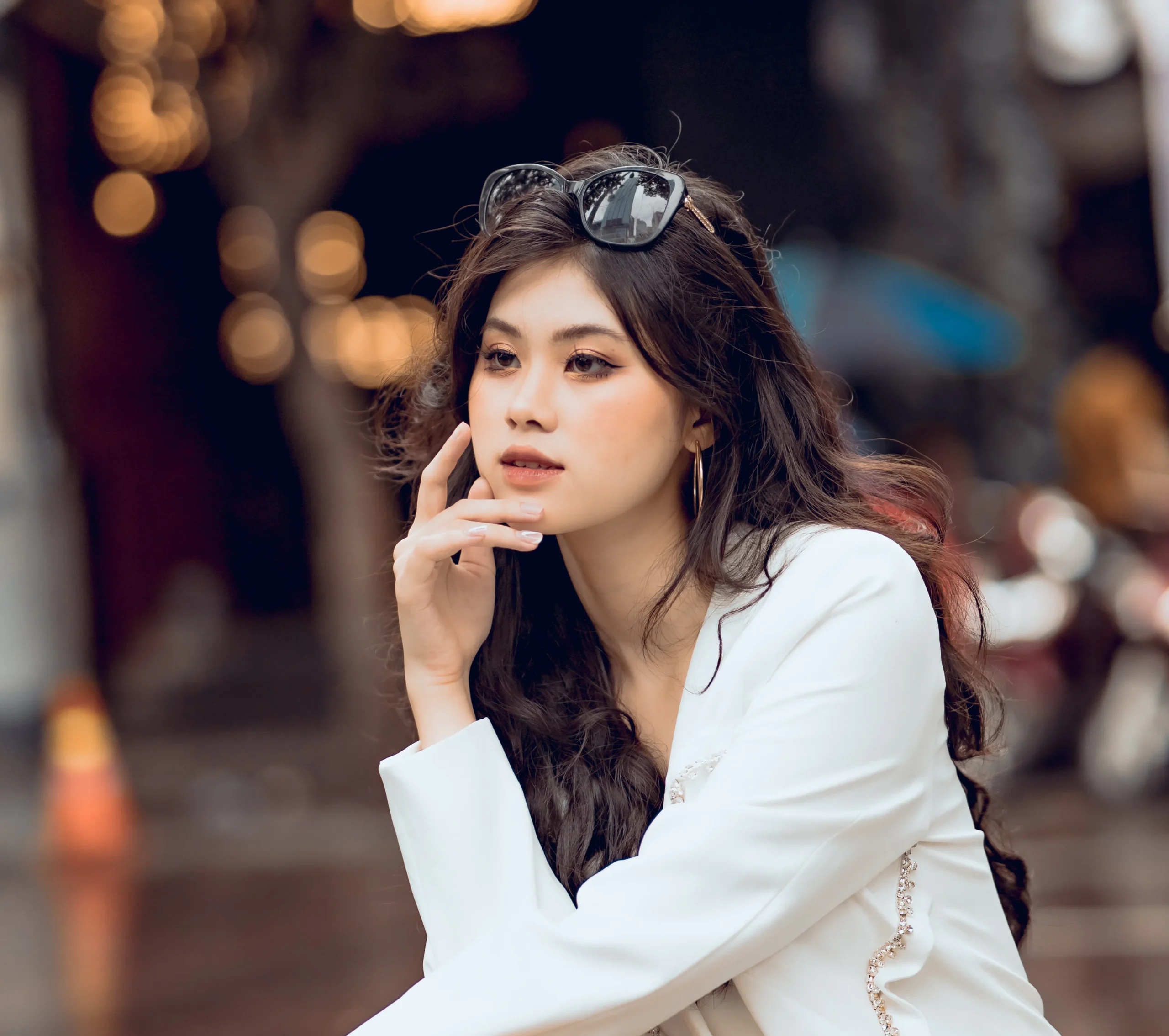 Woman with long brown hair wearing a white jacket, possibly a beautician in Amsterdam.