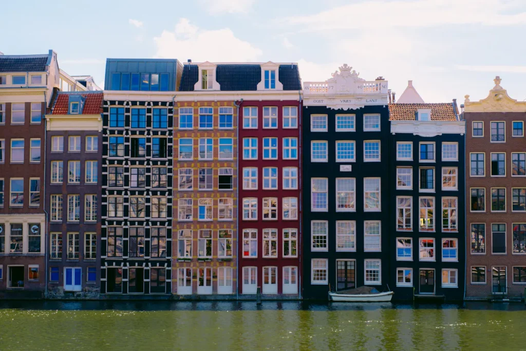 Colorful canal houses reflected in the water in Amsterdam, Netherlands.