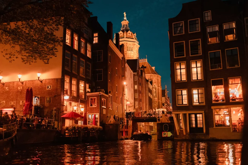 Amsterdam canal at night with illuminated buildings; potential location for carbon peeling.