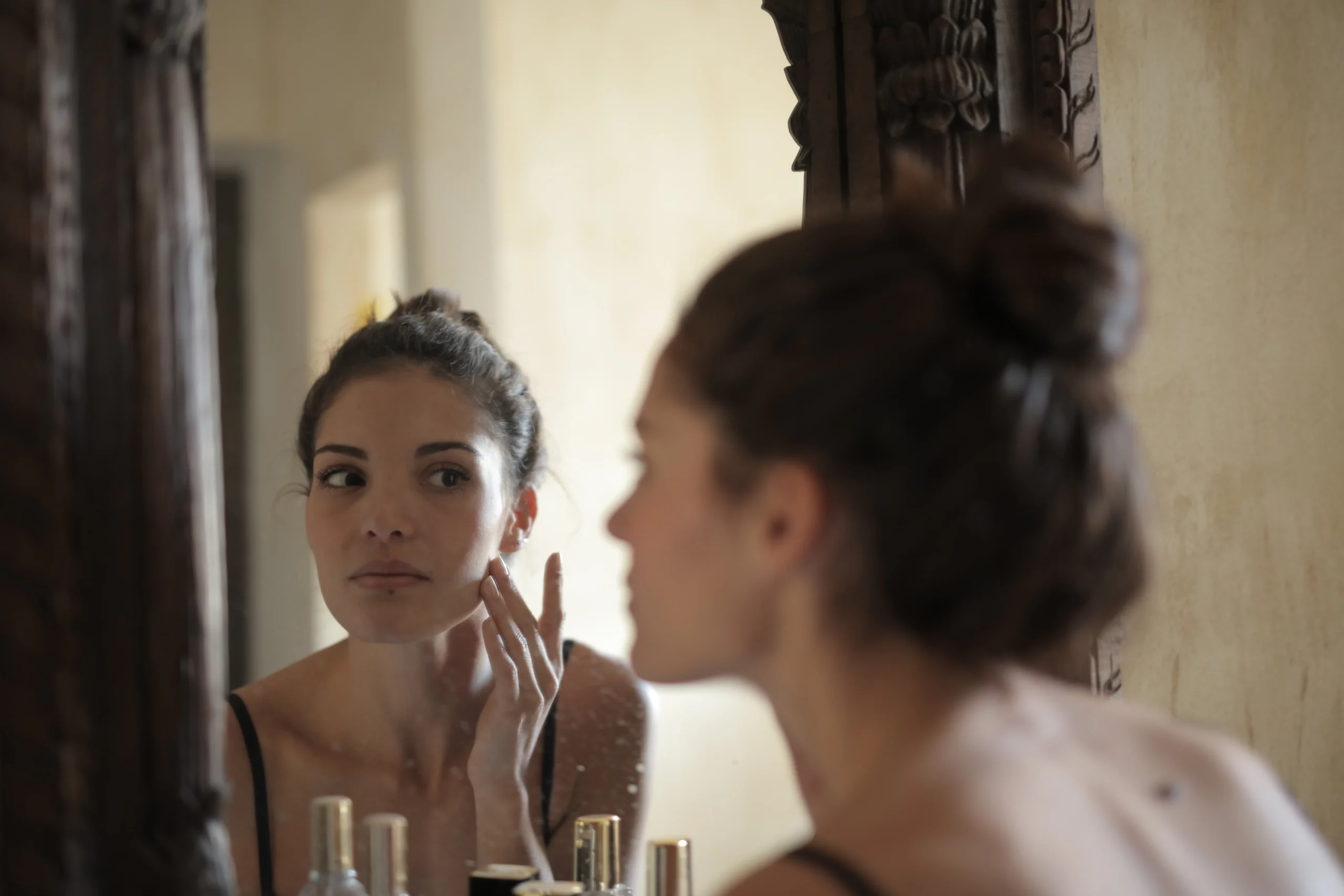 woman checking skin mirror