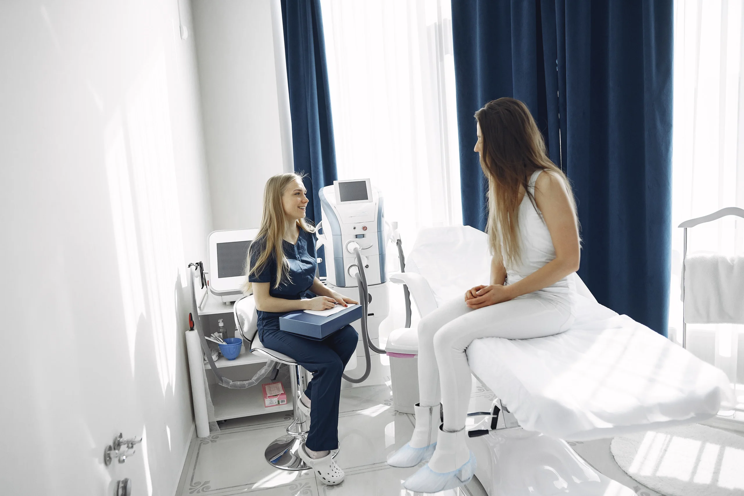 Beautician consulting a client in a modern, bright beauty salon, discussing potential skincare treatments in Amsterdam.