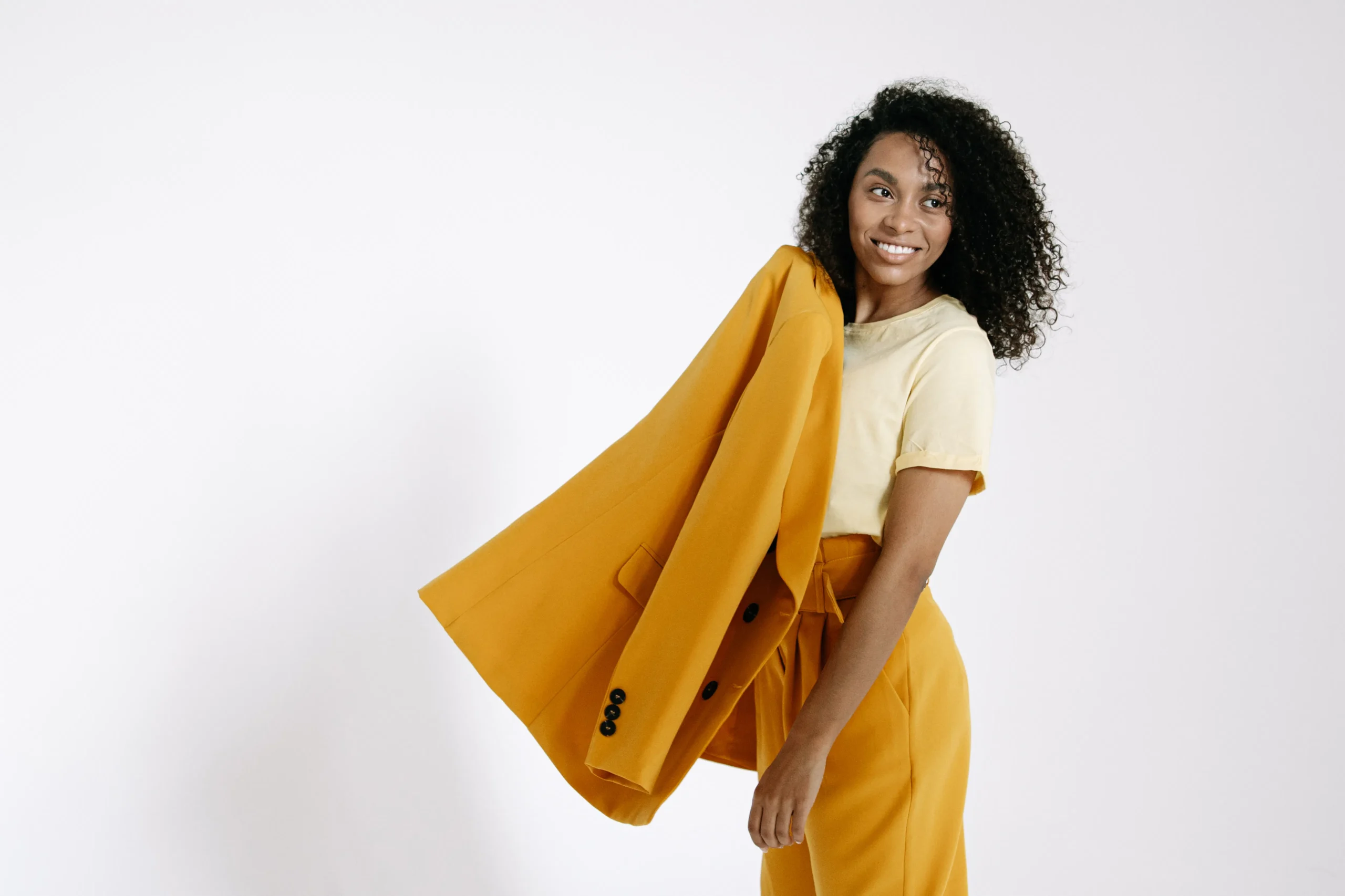Smiling woman in yellow suit, possibly after a beauty treatment Amsterdam.